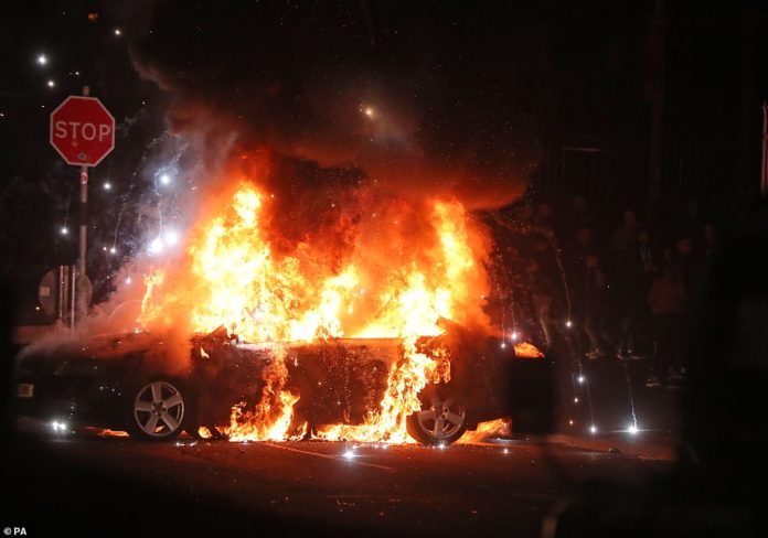 12458218-6938563-A_car_was_torched_by_the_mob_as_violence_erupted_on_the_streets_-a-7_1555643992752