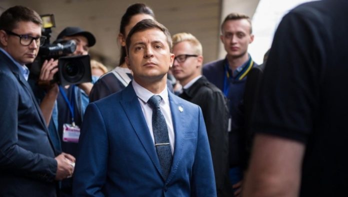 bnePeople_Ukraine__Volodymyr_Zelenskiy_with_press_blue_suit_Cropped