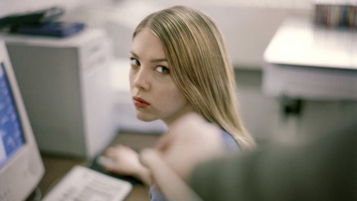 woman at desk giving dirty look to prankster.