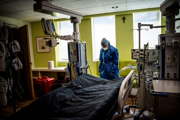 Anne Marie Baker, a nurse at the Children's Hospital of San Antonio in Texas, on Aug. 10, 2021, disinfects the room of a teenager who had just died from COVID-19. (Meridith Kohut/The New York Times)