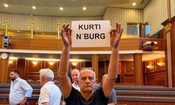 Një mërgimtar shkon në Kuvend me pankartën   Kurti n burg 